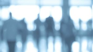 A blurred photo of people walking in front of windows