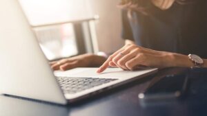 A businesswoman typing on a laptop keyboard