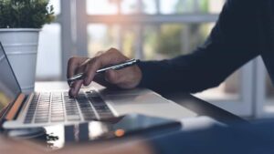 Hands working on a laptop keyboard