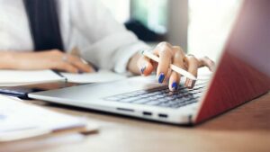 Woman's hand typing on a laptop keyboard