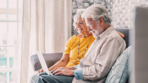 Older man and woman looking at laptop.