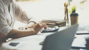 A person using a calculator at a desk.