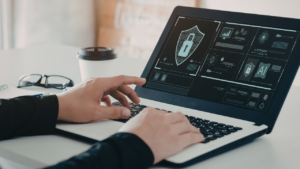 Person using a laptop, cybersecurity screen