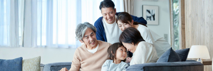 A family of five gathers around a couch.