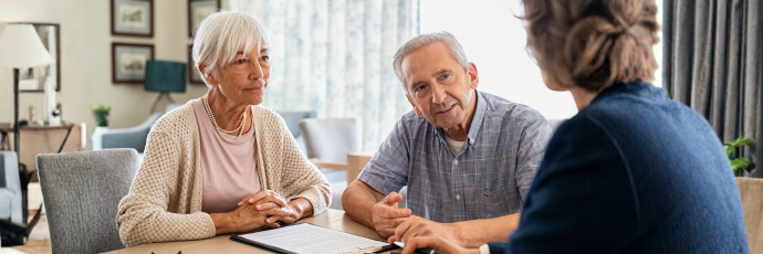 An elderly man and woman meet with their attorney.