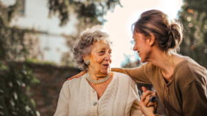 An adult child holding hands with her aging mother.