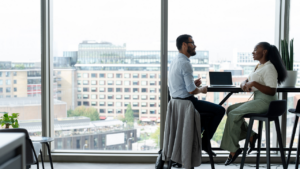 An outsourced controller and CFO having a meeting at a high top table.